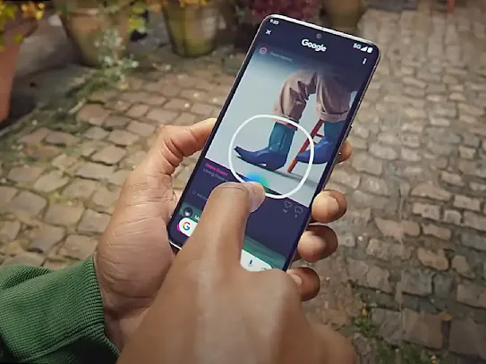 Tela de um celular com um homem utilizando a função Circule para Pesquisar em uma imagem.