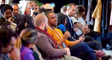 A guy speaking something on mic among the group of people
