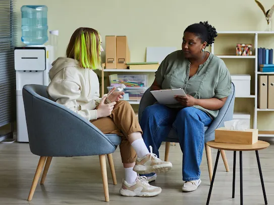 Photograph of a social worker speaking with a teenager.