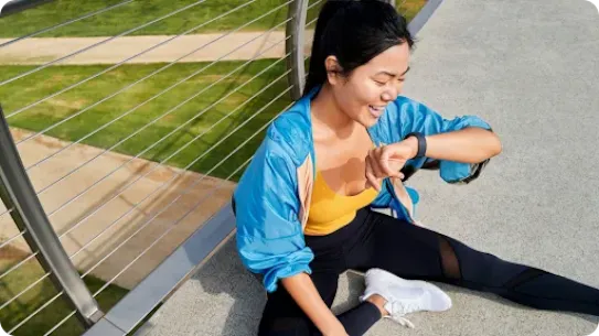 Woman sitting and looking at her smartwatch