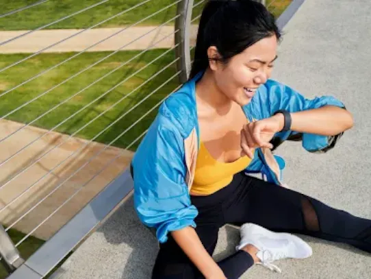 Woman sitting and looking at her smartwatch