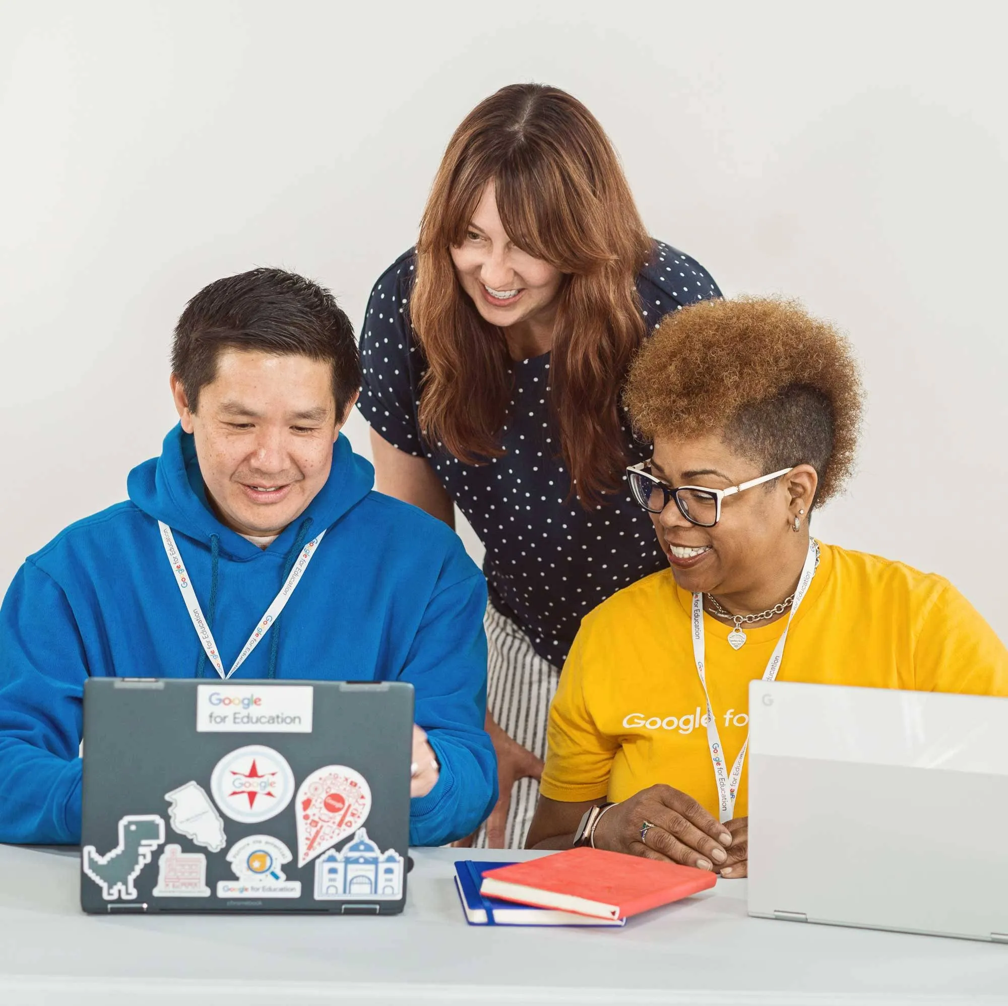 Three individuals gather around a laptop, eager to learn new skills.