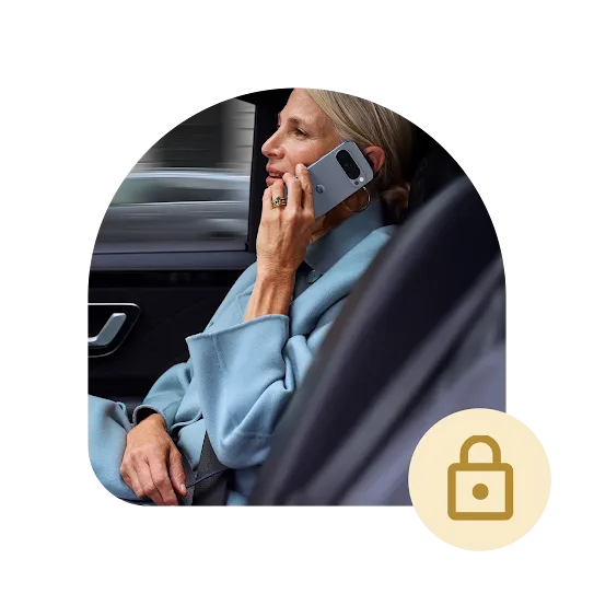 A person wearing a light blue peacoat is inside a car talking on their Pixel phone. A lock icon is right below the image. 