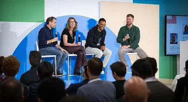 3 men and a woman sitting on chair holding mic on stage