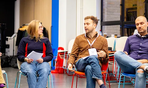 A woman and two man sitting on on a chair.