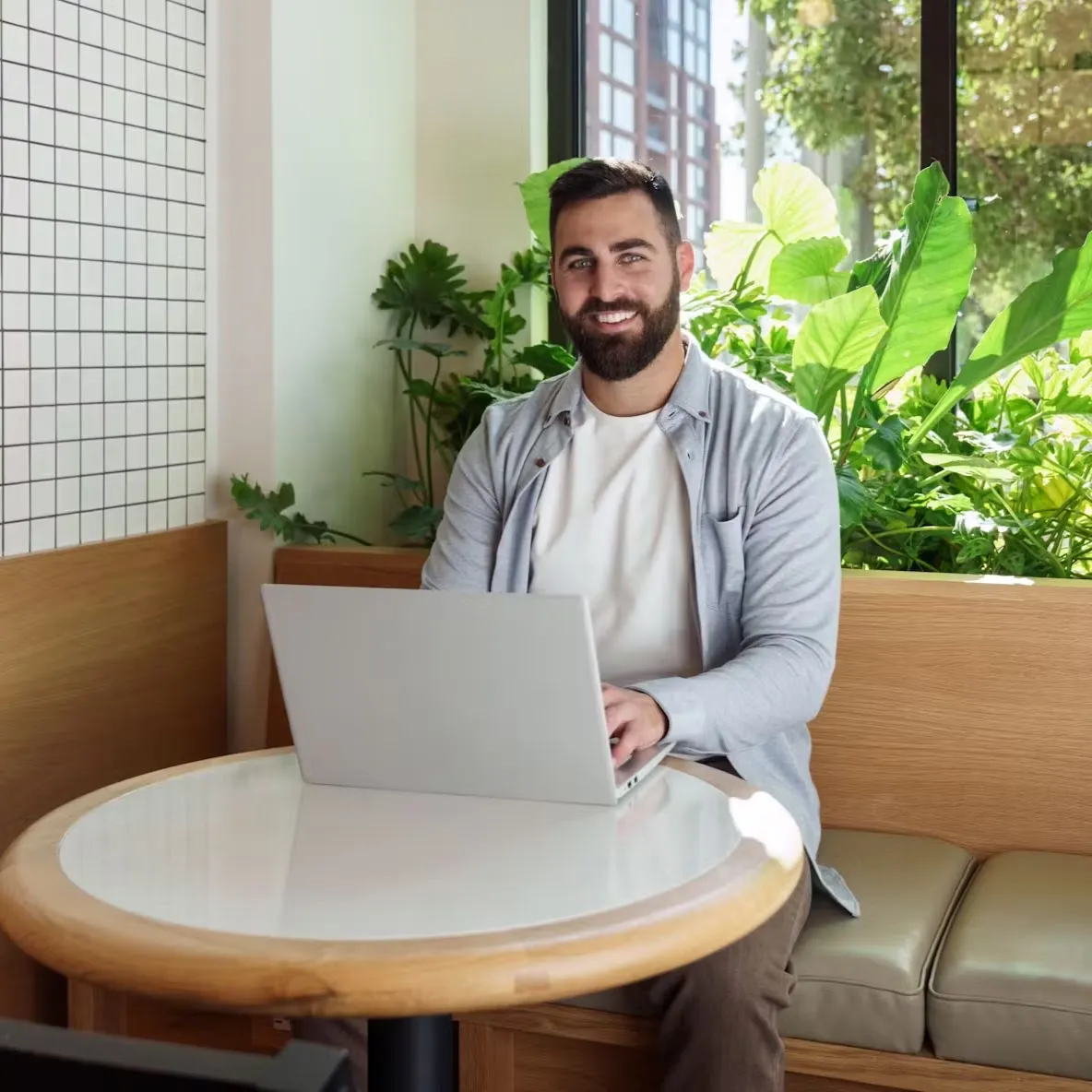 A person sitting in an open air office, doing work on a laptop