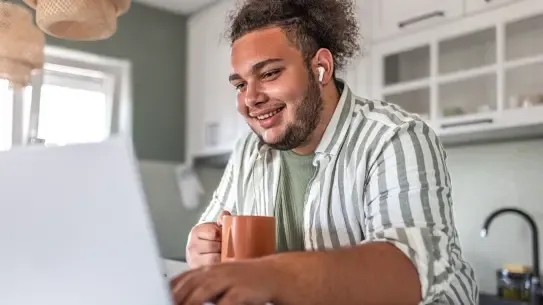  young adult using laptop and headphones