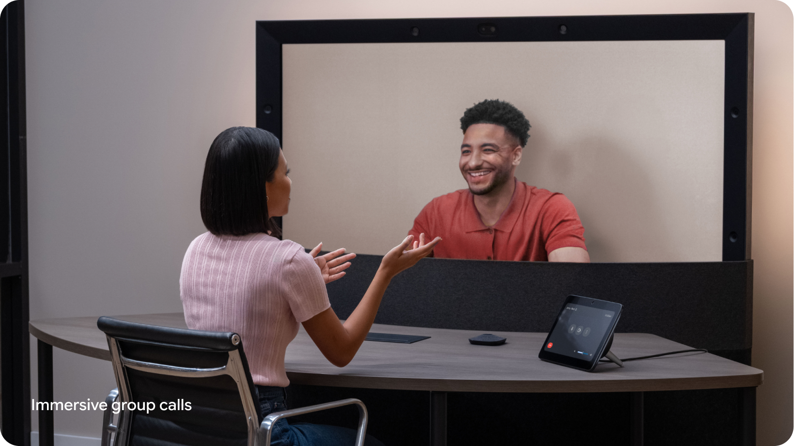 A person gestures with their hands while chatting with a colleague during a Google Beam video meeting.