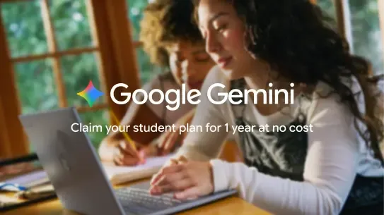 two students doing homework at a table with a laptop and a notebook