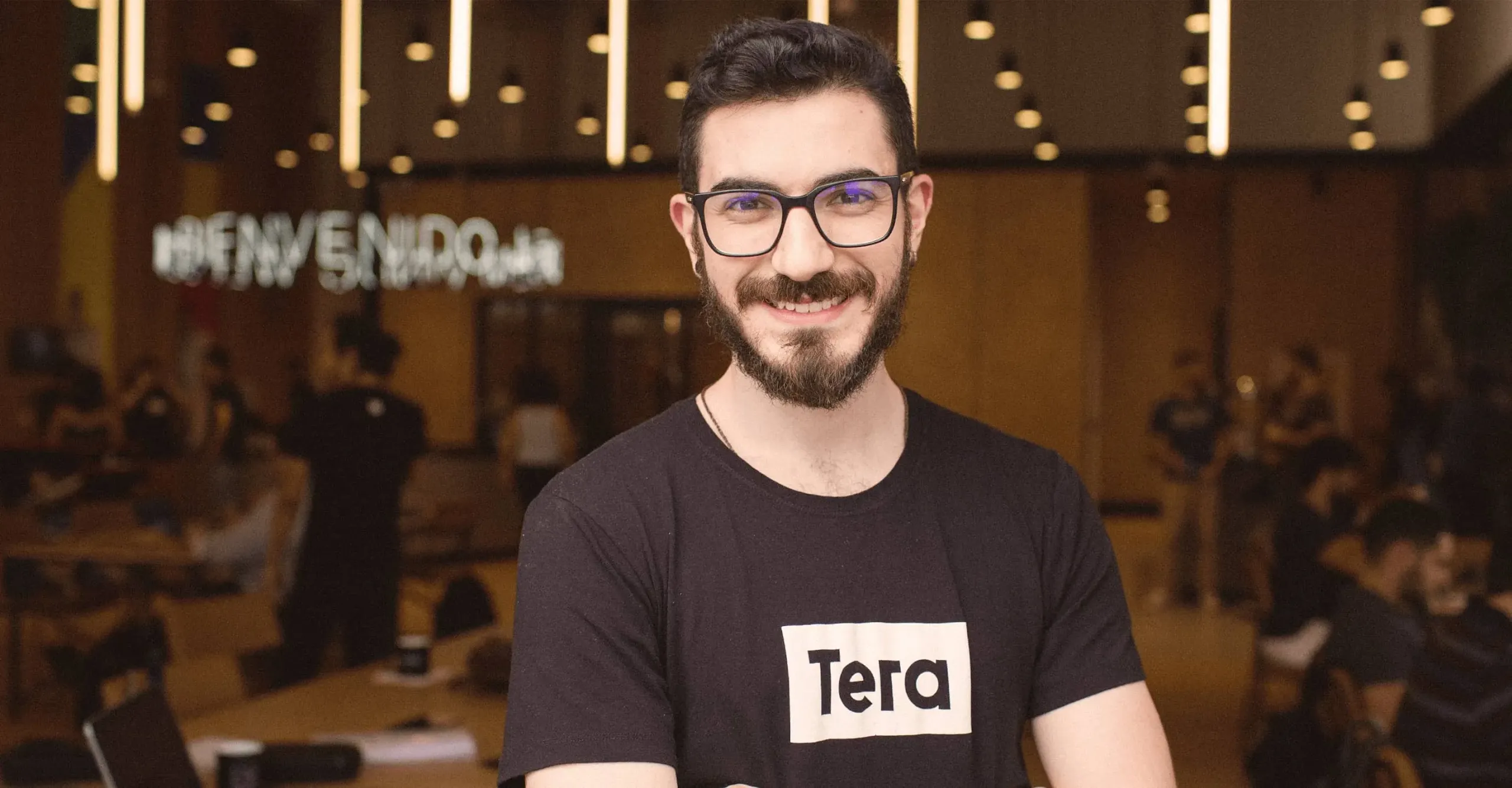 Grupo de pessoas posando para foto junto a uma placa com o logo da Tera.