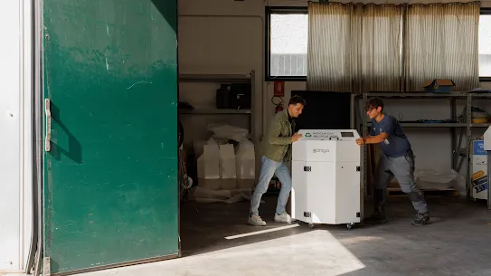 Two people with a recycling machine 