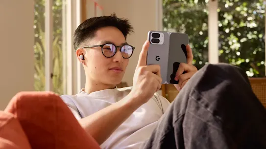 Man sitting at a couch and attentively looking at his Android device's screen. 