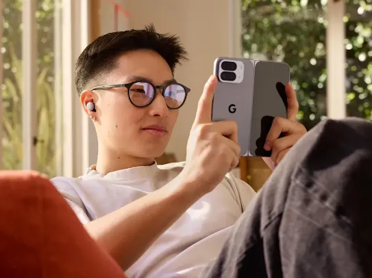 Man sitting at a couch and attentively looking at his Android device's screen. 
