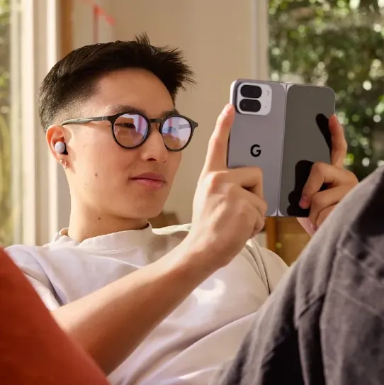 Man sitting at a couch and attentively looking at his Android device's screen. 