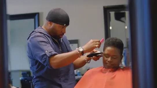 man cutting woman's hair in barber shop