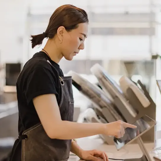 Coffee shop employee tapping on a tablet.