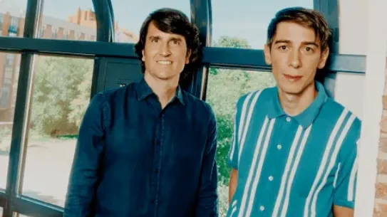 Carlos Nueno and Nacho Medrano standing together in front of a large arched window, representing the partnership between Teladoc Health and Savana to use AI for heart health.