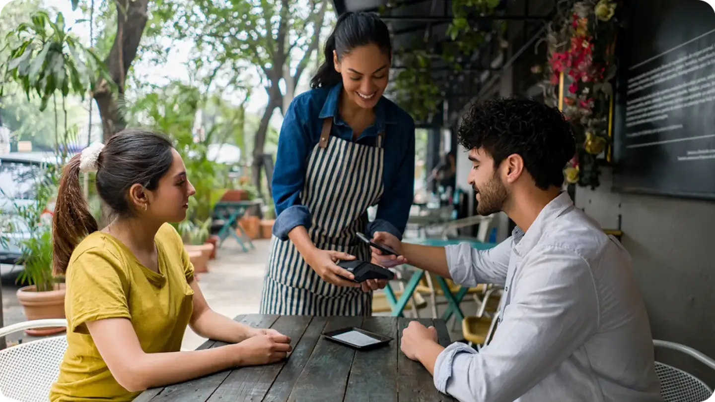 Two customers enjoy the drinks that they purchased using Tap and Pay on their smartphones.