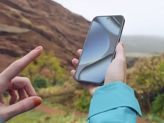 A woman using an Android phone in the wilderness.
