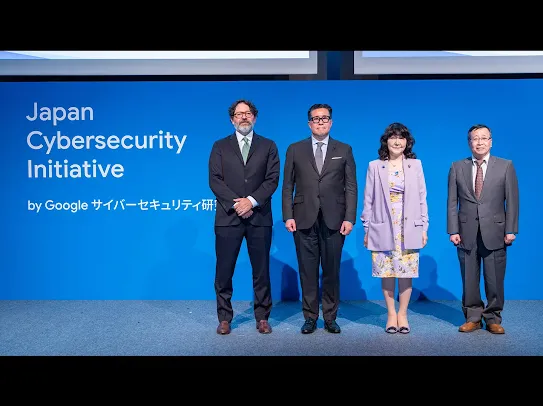 2026 年 4 月 13 日開催のGoogle主催イベント『Japan Cybersecurity Initiative シンポジウム』での集合写真。『Japan Cybersecurity Initiative by Google サイバーセキュリティ研究所』と書かれた青い背景パネルの前に 4 名が並んで立っている。左から、Google プライバシー セーフティ セキュリティ担当 バイス・プレジデントのロイヤル・ハンセン、Google 日本法人 代表の奥山真司、財務大臣 / 内閣府特命担当大臣（金融）の片山さつき様、日本サイバーセキュリティ・イノベーション委員会 代表理事の梶浦敏範様。