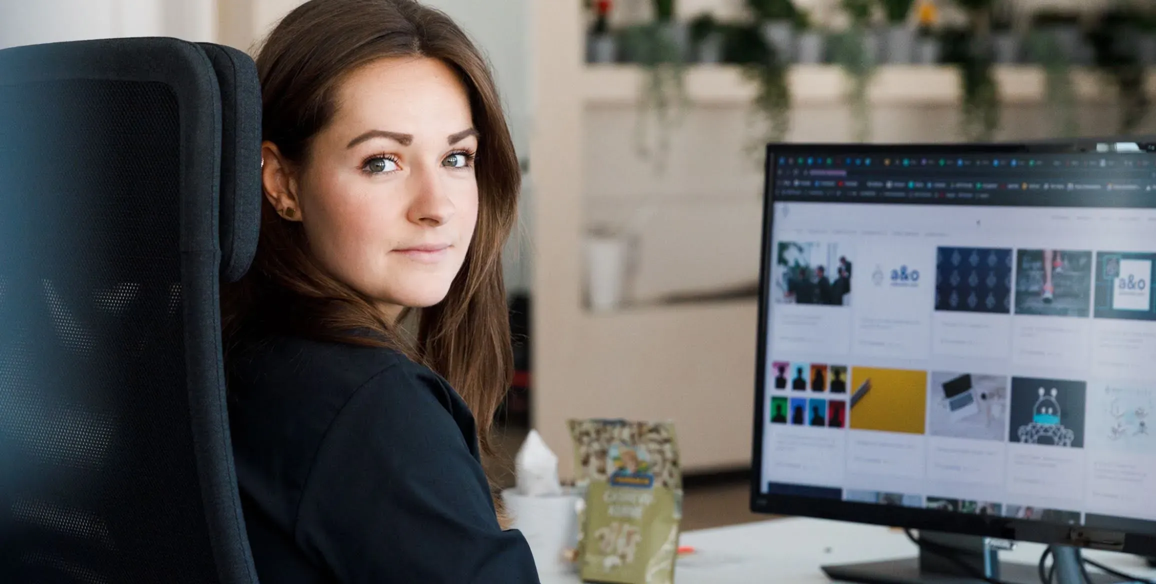 a woman operating a computer looking at the camera