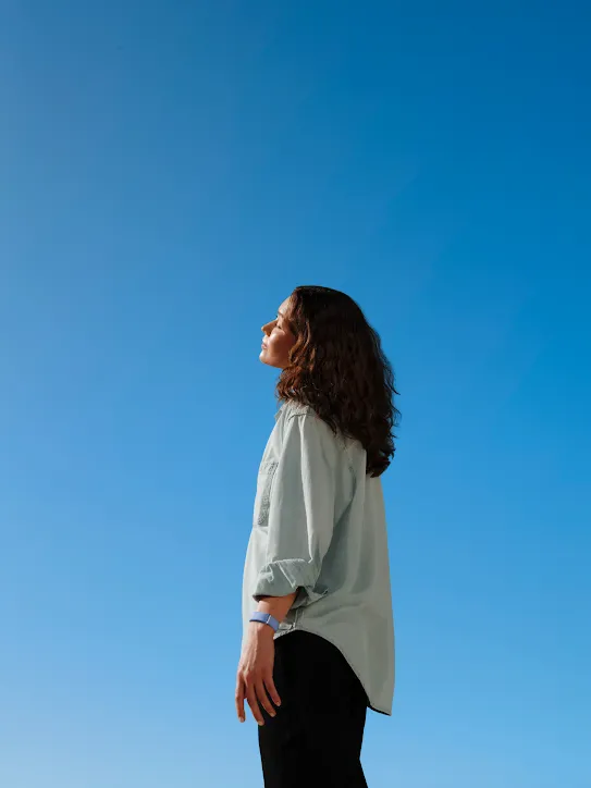 A woman faces the sun with her eyes closed.