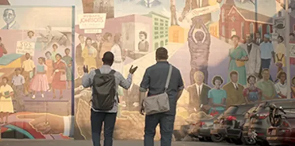 Founders, Justin and Bernard, are walking in front of a mural.