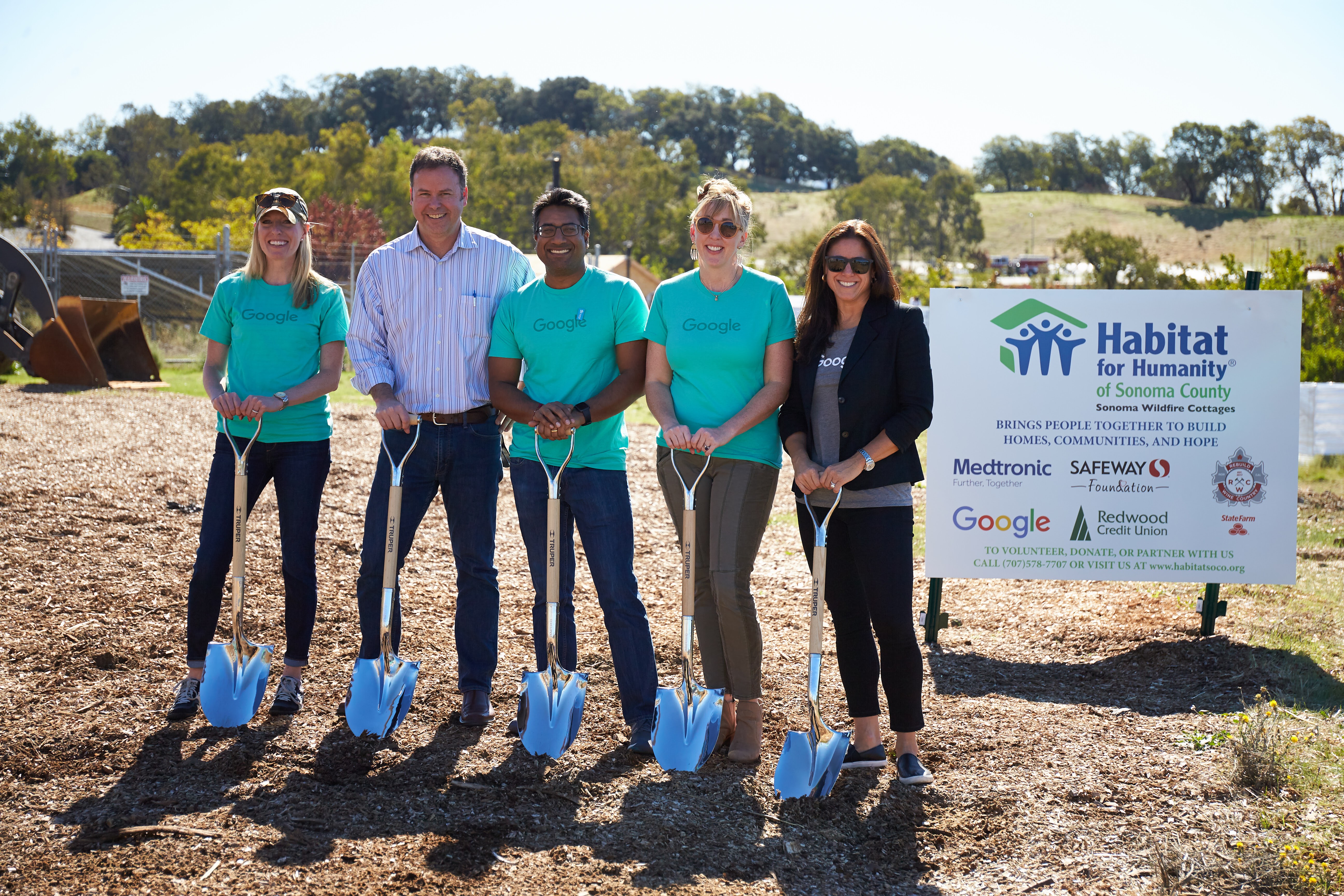 Five people holding shovels as they volunteer to help build sustainable housing in collaboration with Google and Habitat for Humanity, a partnership that is based on the shared belief that energy-efficiency is a critical piece of building sustainable homes and communities.