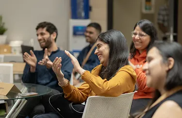 A group of people clapping while laughing.