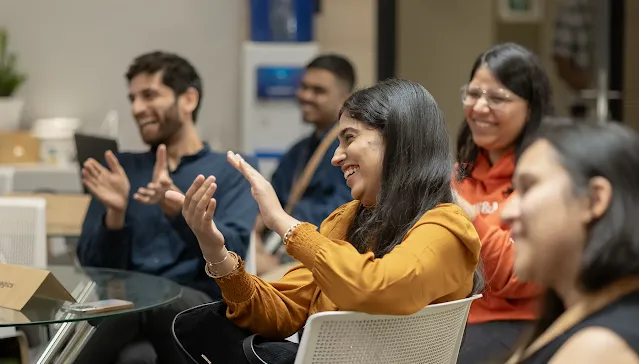 A group of people clapping while laughing.