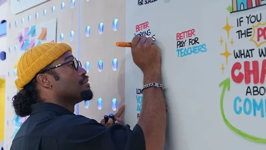 A man writes on a large piece of paper