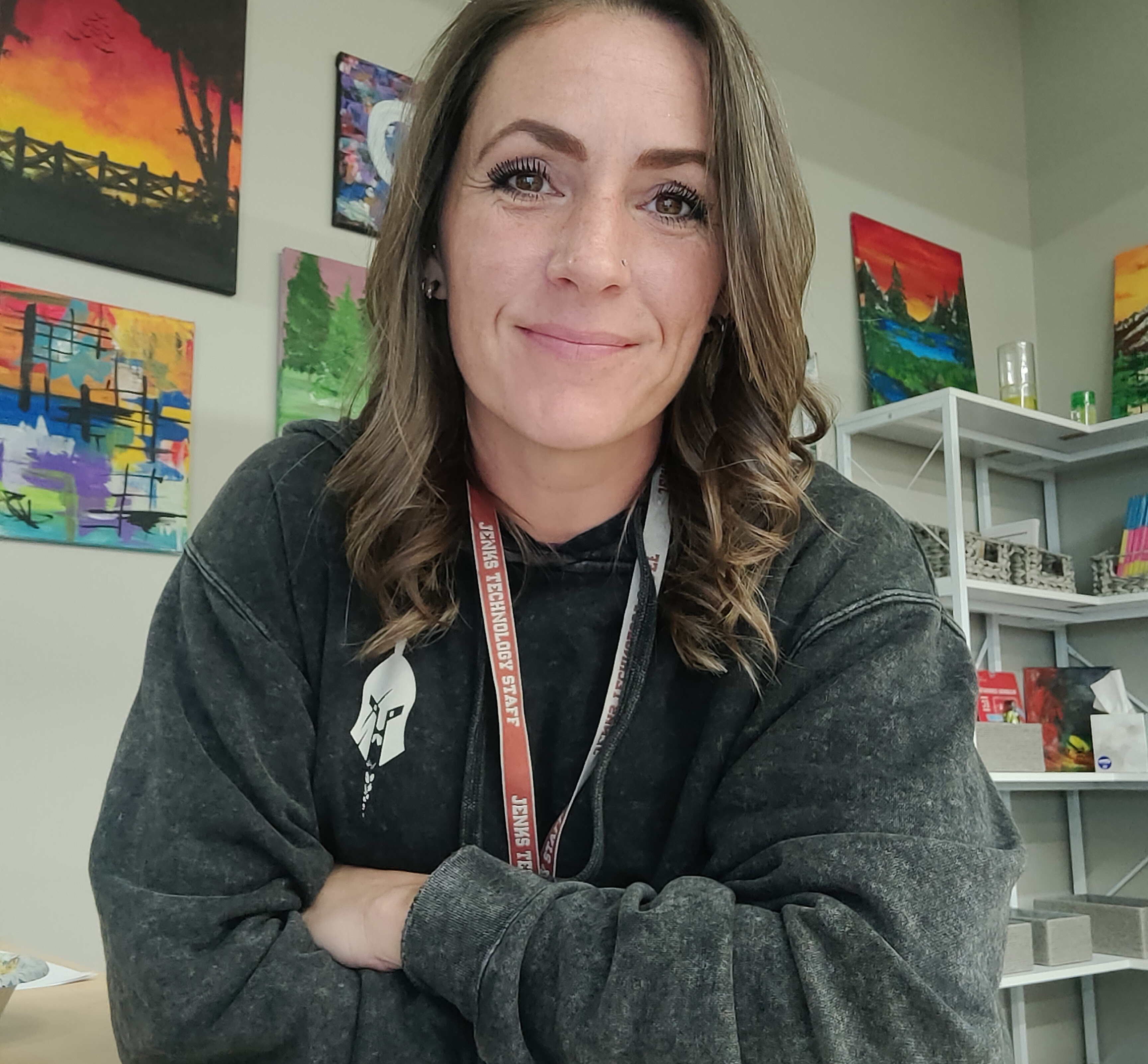 Woman sitting at a desk with arms crossed, smiling at the camera