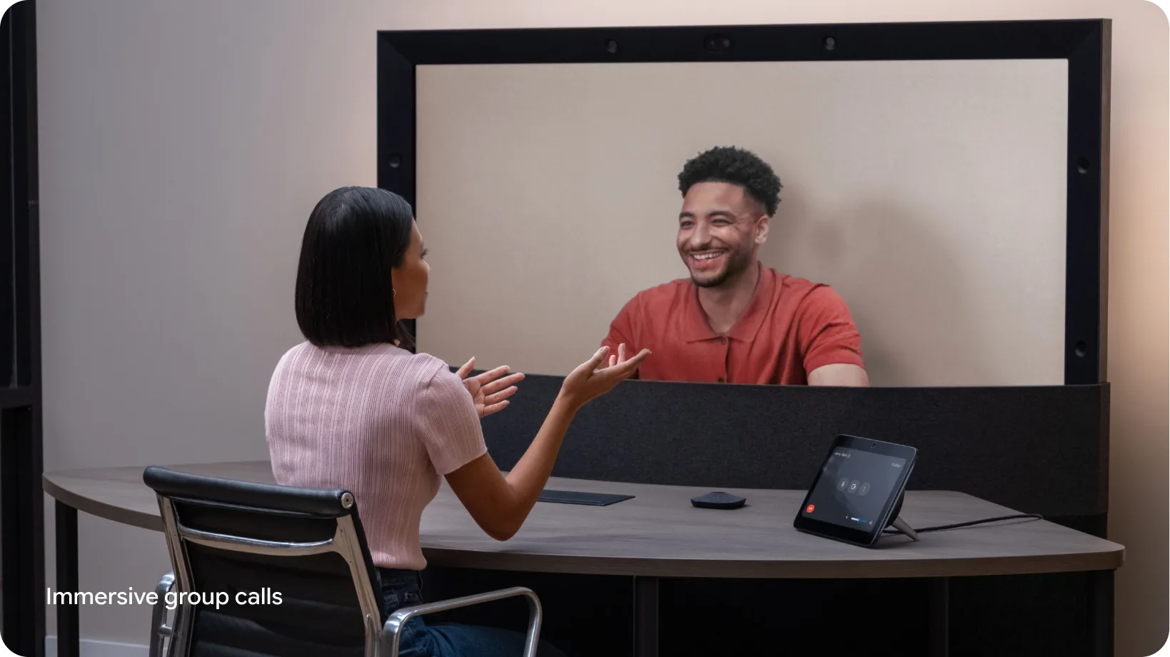 A person gestures with their hands while chatting with a colleague during a Google Beam video meeting.