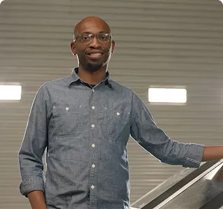 Founder Seyi Fabode smiles at the camera inside his garage-turned-office.