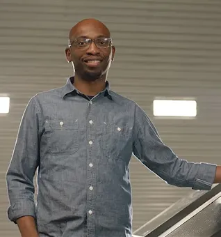 Founder Seyi Fabode smiles at the camera inside his garage-turned-office.