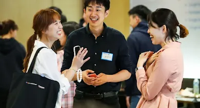 Two women and a men discussing something and laughing.