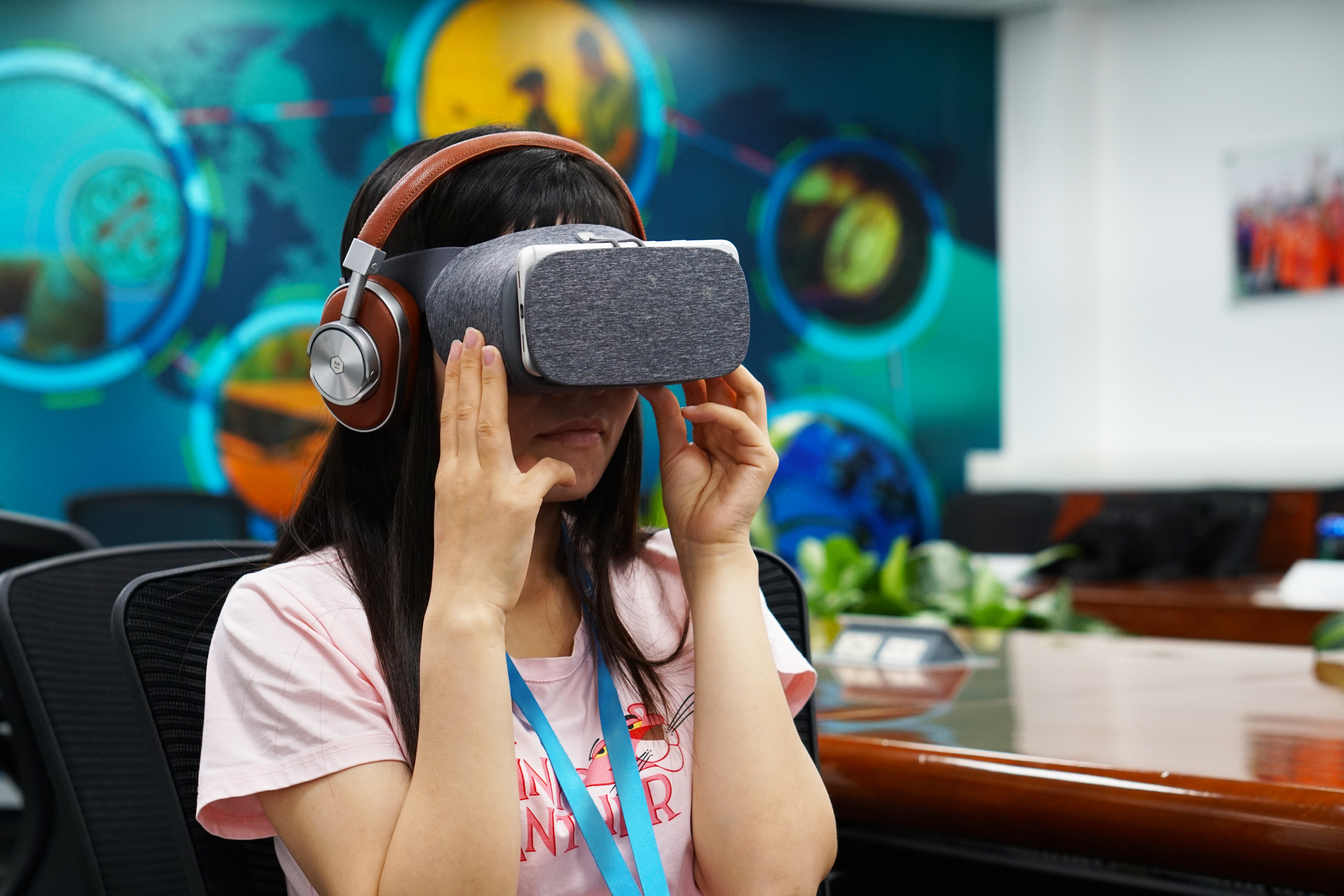 A person sitting in a chair and using a VR headset.