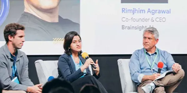 Panel discussion with speakers on stage and an audience seated in front.