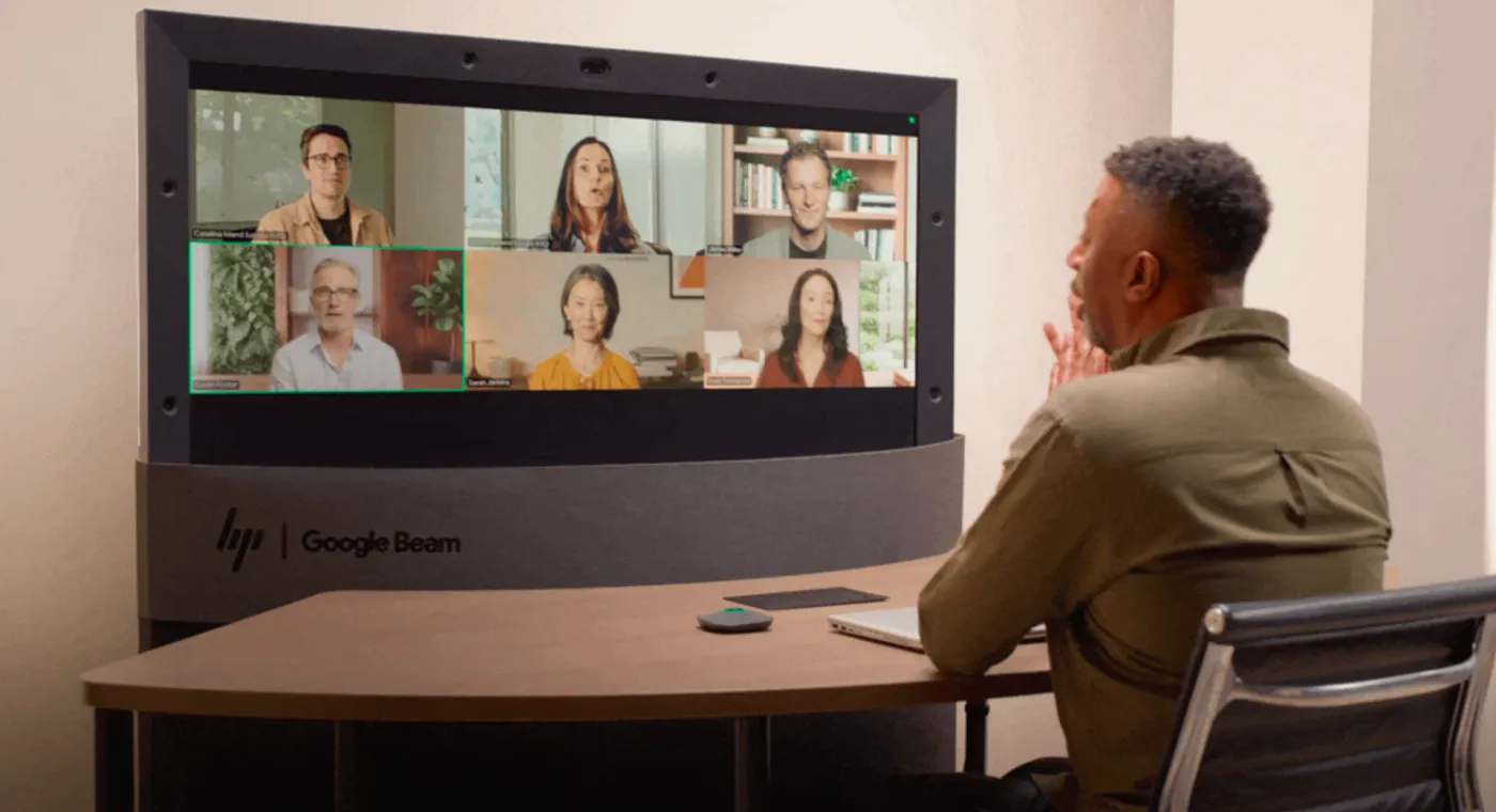 A carousel of images and videos shows the evolution of Google Beam devices over time.
A person talks expressively during a group Google Beam video meeting.