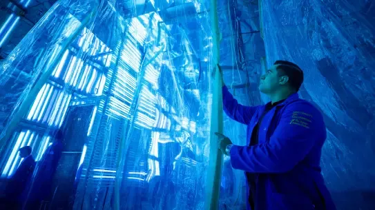 person in a University of California jacket working in a research building