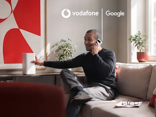 Mann sitzt auf Sofa und telefoniert