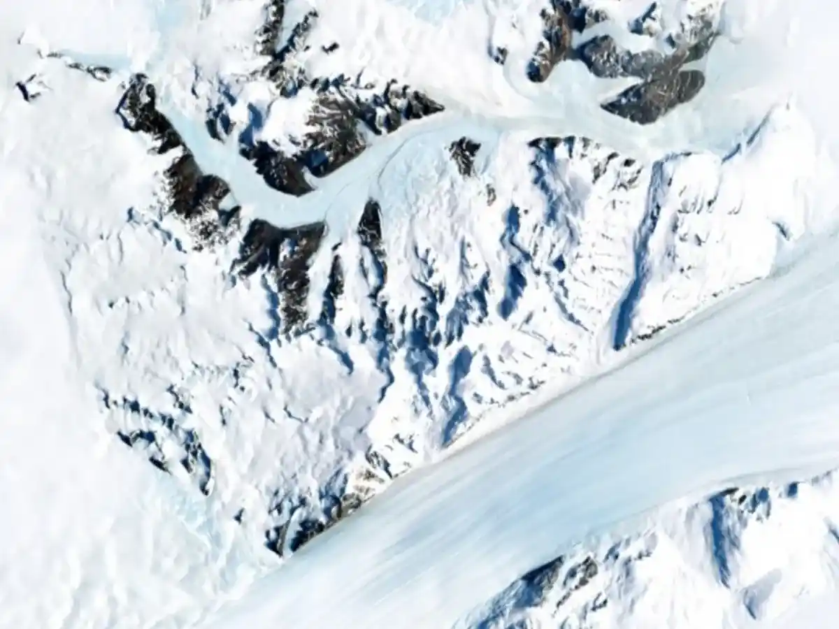 Aerial image of snow showing earth beneath, to signify glacier melt