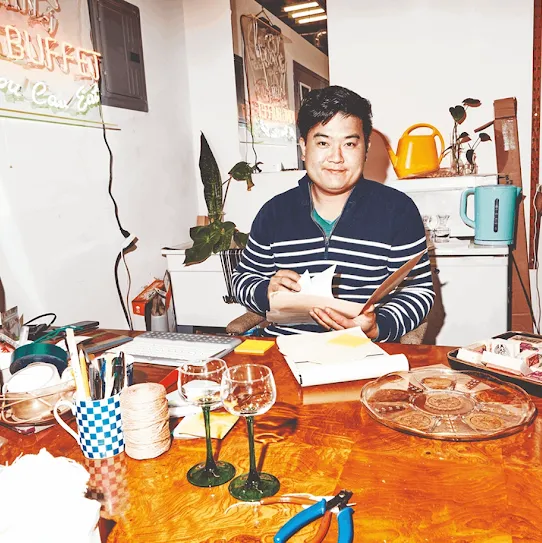 Man sitting at a desk, sorting through various papers