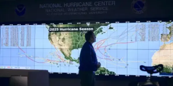 Meteorologist reviewing patterns on map labeled 2025 hurricane season at the National Hurricane Center
