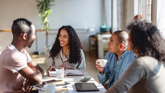 A group of four coworkers have a work meeting.