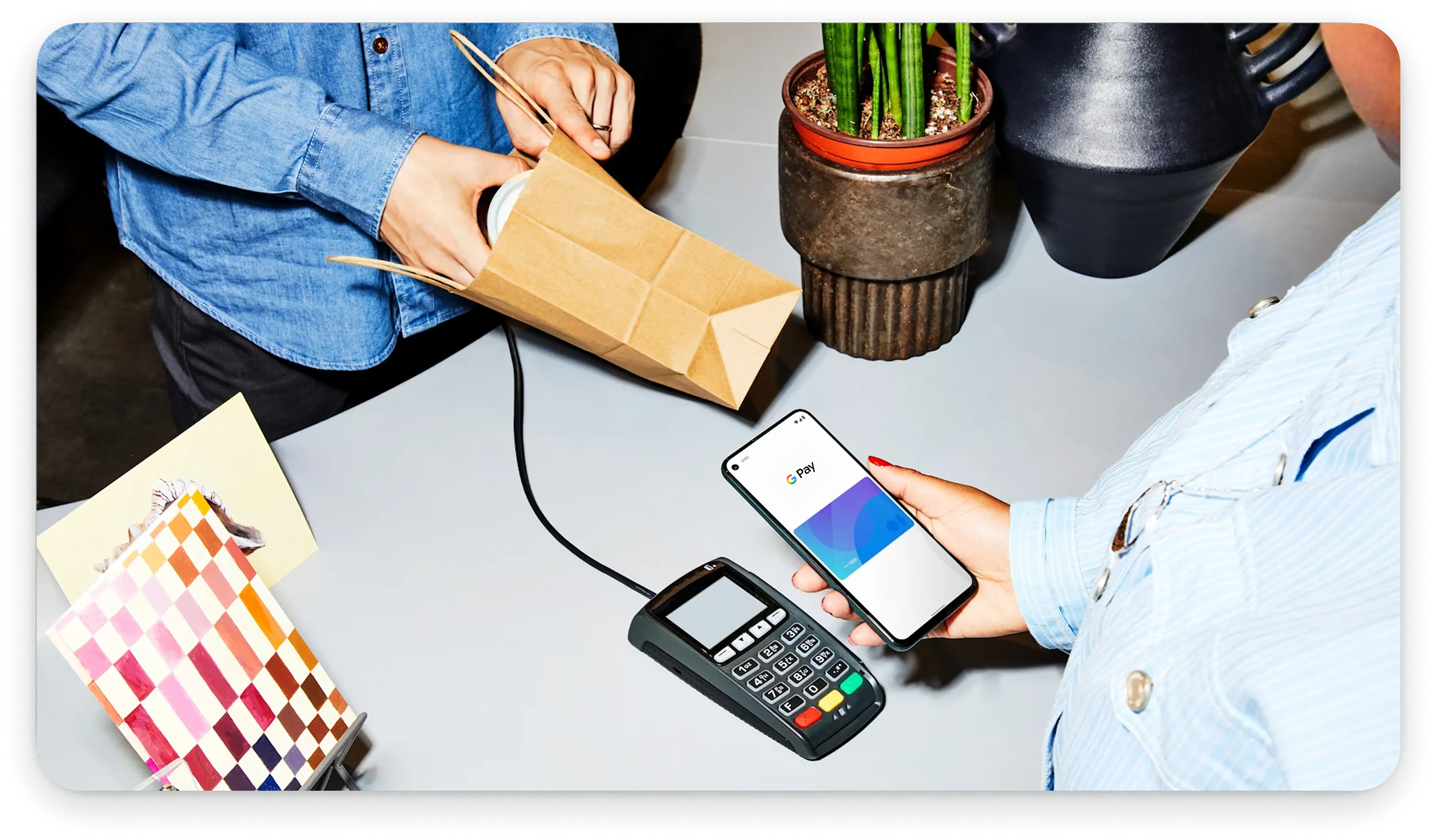 คนถือโทรศัพท์ไว้ใกล้กับเครื่องชำระเงินแบบไม่ต้องสัมผัส