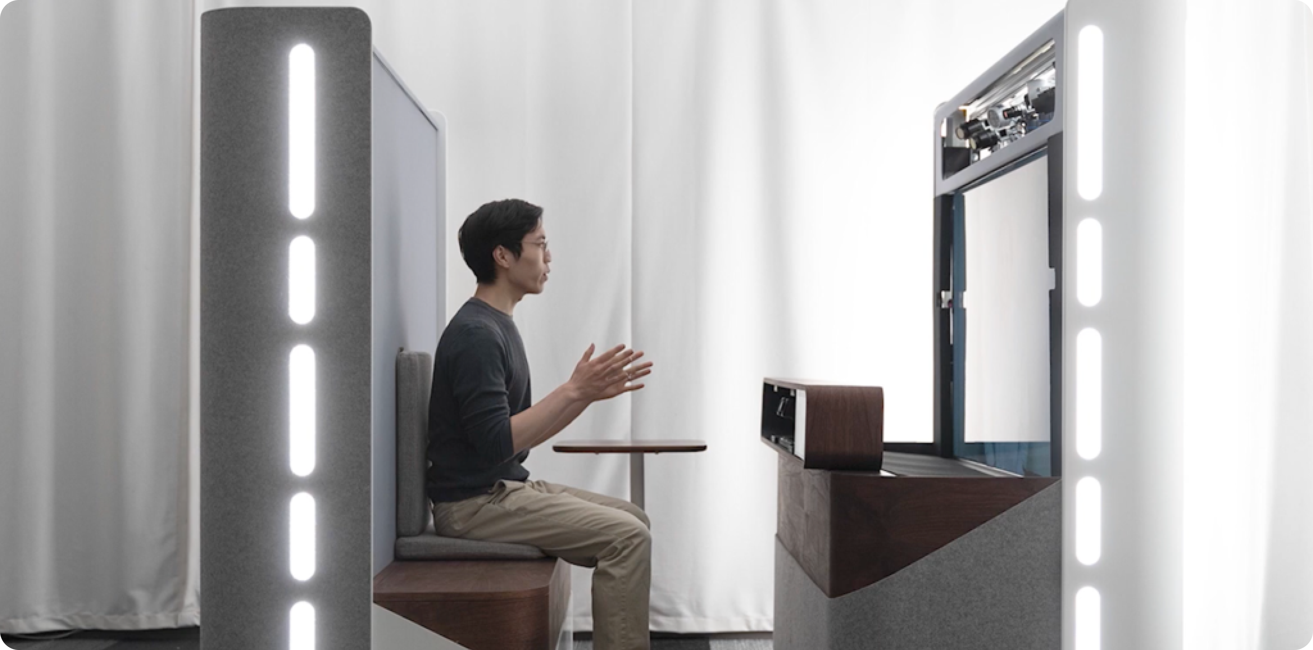 A side-profile view of a person seated in front of a Project Starline prototype device.