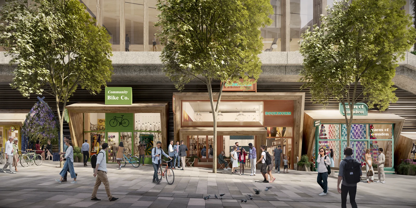 Una imagen generada por computadora que muestra la planta baja del nuevo edificio de Google en King’s Boulevard. Aparecen tres tiendas: una bicicletería, una librería y una tienda de textiles. Se ven varias personas en primer plano.