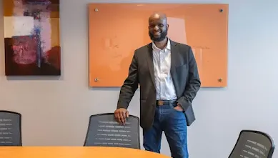 One of the male co-founders of Ilmiya posing at a desk
