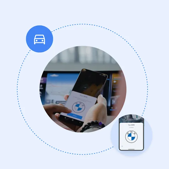 A pair of hands holding a phone in front of a tablet mounted on a car dashboard, displaying a &quot;Connect&quot; button and the BMW logo. Surrounding this, the BMW logo and a car icon are connected by a dotted line.